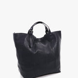 Große Frau mit blauer Lederkäufertasche