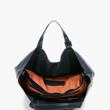 Große Frau mit blauer Lederkäufertasche