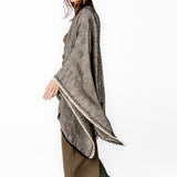 Poncho mit schwarzem Linienmuster.