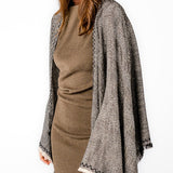 Poncho mit schwarzem Linienmuster.