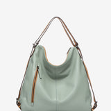 Convertible bag into a backpack in green die-cut leather
