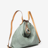 Convertible bag into a backpack in green die-cut leather