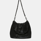 Schultertasche aus schwarzem Metallgewebe.