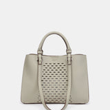 Handtasche aus recycelten Materialien in Grün mit Stanzmuster.