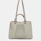 Handtasche aus recycelten Materialien in Grün mit Stanzmuster.