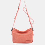 Damentasche aus korallenfarbigem, gestanztem Leder.