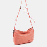Damentasche aus korallenfarbigem, gestanztem Leder.