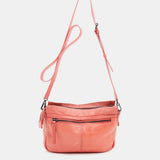 Damentasche aus korallenfarbigem, gestanztem Leder.