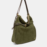 Multifunktionale Tasche aus grünem Veloursleder.
