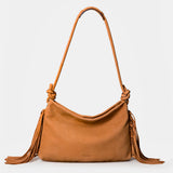 Shoulder bag in cognac leather with fringe details.