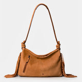 Shoulder bag in cognac leather with fringe details.