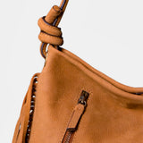 Shoulder bag in cognac leather with fringe details.
