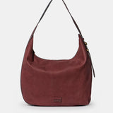 Schultertasche aus weinrotem Veloursleder.
