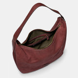 Schultertasche aus weinrotem Veloursleder.