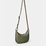 Schultertasche aus grünem Wildleder.