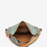 Convertible bag into a backpack in green die-cut leather