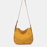 Schultertasche aus recycelten Materialien in Bernsteinton.