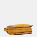 Schultertasche aus recycelten Materialien in Bernsteinton.