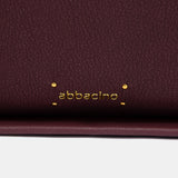 Burgundy shoulder bag made from recycled materials.
