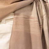 Verstellbarer Poncho mit beigem Karomuster.