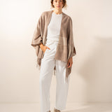Verstellbarer Poncho mit beigem Karomuster.