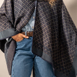 Poncho mit blauem geometrischem Muster.