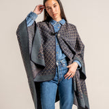 Poncho mit blauem geometrischem Muster.